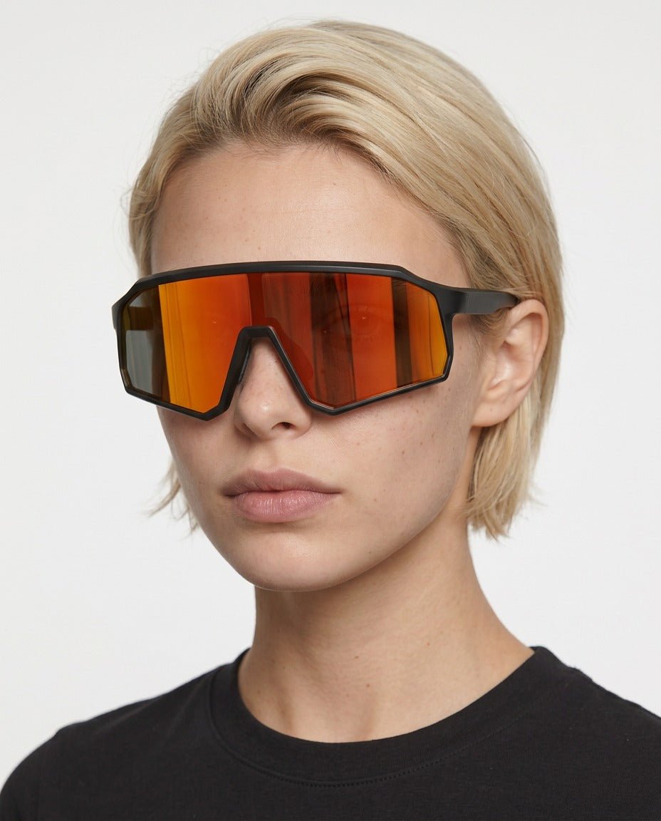 Brooklyn sport shield sunglasses in Orange / Black, orange lens on black frame, worn by a woman, front view