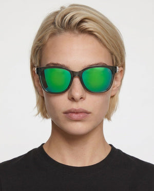 Delta 9 oversized round sunglasses in Green / Smoke Grey, green lens on smoke grey frame, worn by a woman, front view