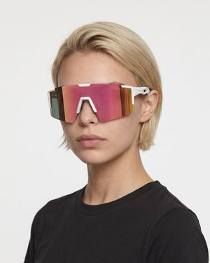 Dial Up sport shield sunglasses in Pink / White, pink lens on white frame, worn by a woman, front view