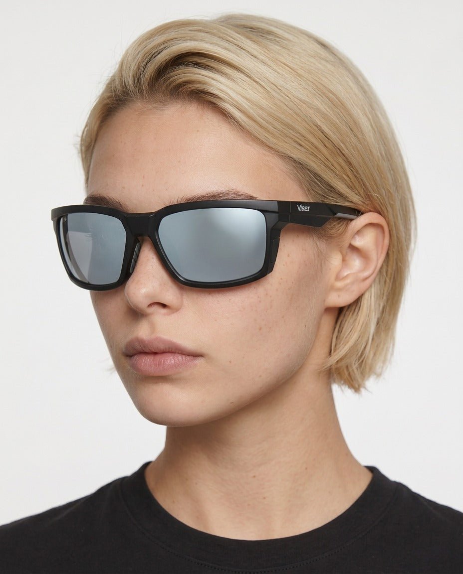 Flux sport wrap sunglasses in Grey / Black, grey lens on black frame, worn by a woman, front view