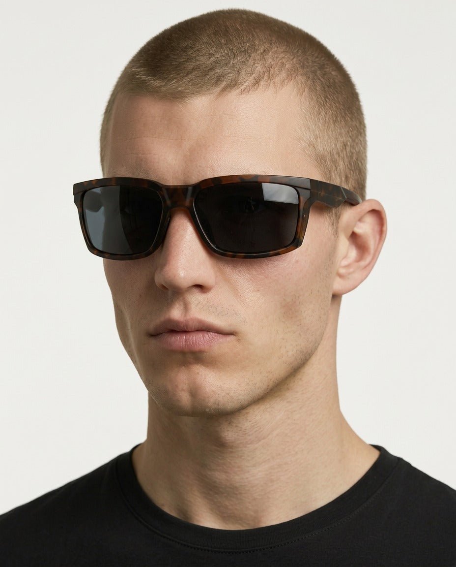 Flux sport wrap sunglasses in Black / Tortoise, black lens on tortoise frame, worn by a man, front view