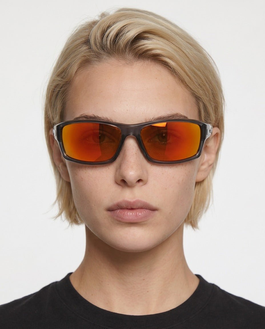 Nova sport wrap sunglasses in Orange / Smoke Grey, orange lens on smoke grey frame, worn by a woman, front view