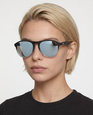 Orbit rounded aviator sunglasses in Silver / Black, silver lens on black frame, worn by a woman, front view
