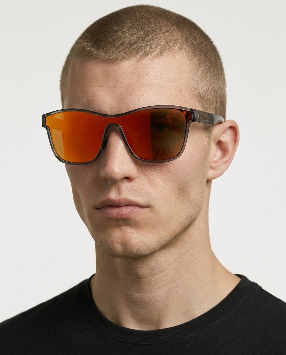 Radar performance wrap sunglasses in Red / Black, red lens on black frame, worn by a man, front view