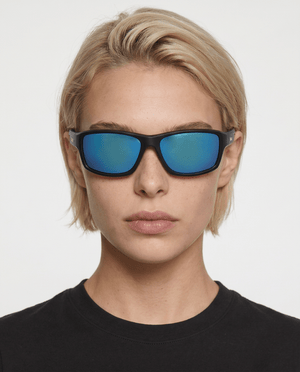 Nova sport wrap sunglasses in Blue / Black, blue lens on black frame, worn by a woman, front view