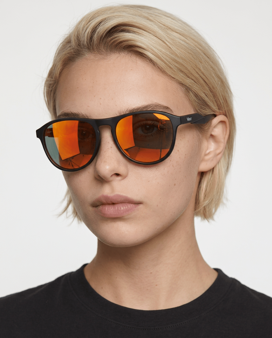 Orbit rounded aviator sunglasses in Orange / Black, orange lens on black frame, worn by a woman, front view