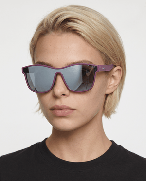 Radar performance wrap sunglasses in Silver / Purple, silver lens on purple frame, worn by a woman, front view