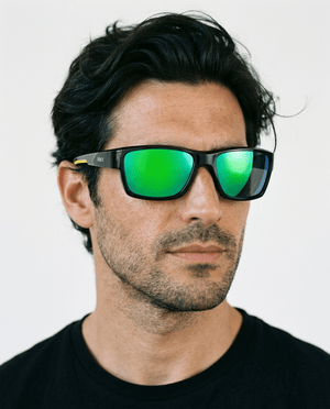 Specter slim wrap sunglasses in Green / Black, green lens on black frame, worn by a man, front view