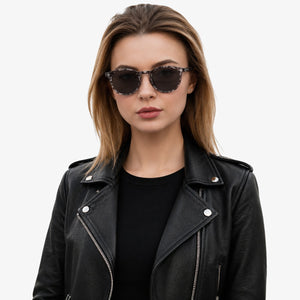 Onyx round retro sunglasses in Black / White Tortoise, black lens on white tortoise frame, worn by a woman, front view
